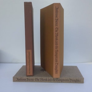 May include: Two brown hardback books with the title "Ambrose Bierce: The Monk and the Hangman's Daughter" on the spine and front cover.