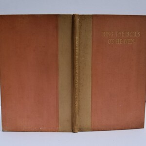 May include: A vintage book titled "Ring the Bells of Heaven" by A.E. Coppard. The book cover is a soft peach color with a gold spine.
