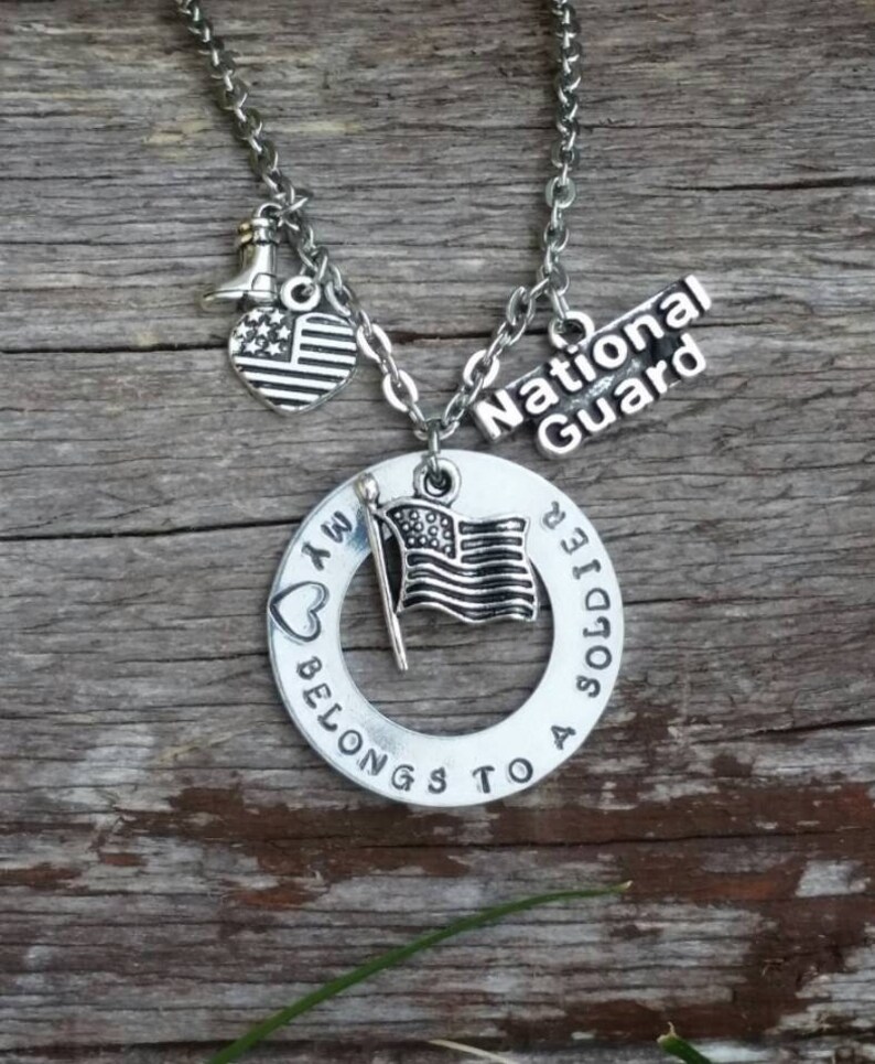 May include: Silver necklace with a heart charm that says "I am a soldier", a circle charm that says "My heart belongs to a soldier", a small American flag charm, and a charm that says "National Guard".