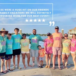 May include: A group of people wearing matching colorful t-shirts with various graphic designs and text, standing on a dock. The image includes a five-star rating and the text: THESE WERE A HUGE HIT ON OUR FRIENDS AND FAMILY VACATION! WE WILL DEFINITELY BE ORDERING MORE FOR OUR NEXT EVENT!