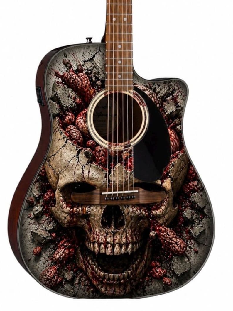 Puede incluir: Guitarra ac&uacute;stica con dise&ntilde;o de calavera. La guitarra presenta un gr&aacute;fico detallado de una calavera que emerge de hormig&oacute;n agrietado, con acentos rojos y grises. El cuerpo tiene un acabado marr&oacute;n oscuro.