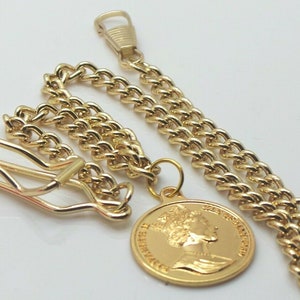 May include: A gold pocket watch chain with a round pendant featuring a profile of Queen Elizabeth II. The chain has a lobster clasp and a swivel hook.