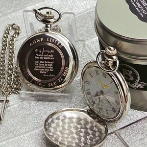 May include: Silver pocket watch with a white face and Roman numeral hour markers. The back of the watch has an inscription that reads "Anne Lister April 3 1791 - Sep 22 1840" and a quote. The watch is in a silver case with a chain.
