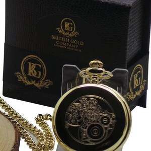 May include: Gold pocket watch with a gold chain and a black box with the text "The British Gold Company Exclusive Gold Gifts".