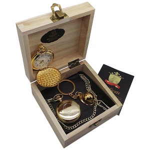 May include: A gold pocket watch with a chain and a certificate in a wooden box. The watch has a white face with black numbers and hands. The box is made of light wood and has a brass latch.