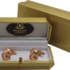 May include: A pair of rose gold cufflinks in a gold gift box. The box is lined with white velvet and has the words "The British Gold Company Exclusive Gold Gifts" printed on the inside lid.