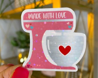 May include: Pink and silver glitter sticker of a stand mixer with the text "Made with Love".