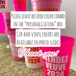 Peut inclure: Des gobelets en plastique rose, blanc et orange avec le texte "Rendez Vous 2024" imprim&eacute; dessus. Les gobelets sont dispos&eacute;s sur une nappe de table dor&eacute;e. Le texte "Veuillez laisser la combinaison de couleurs souhait&eacute;e dans la case "personnalisation". Les couleurs des gobelets et du vinyle sont disponibles dans les diapositives photo. Merci !" est &eacute;crit sur un rectangle blanc.