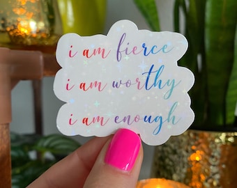 May include: A white sticker with a rainbow iridescent finish and the text "i am fierce, i am worthy, i am enough".
