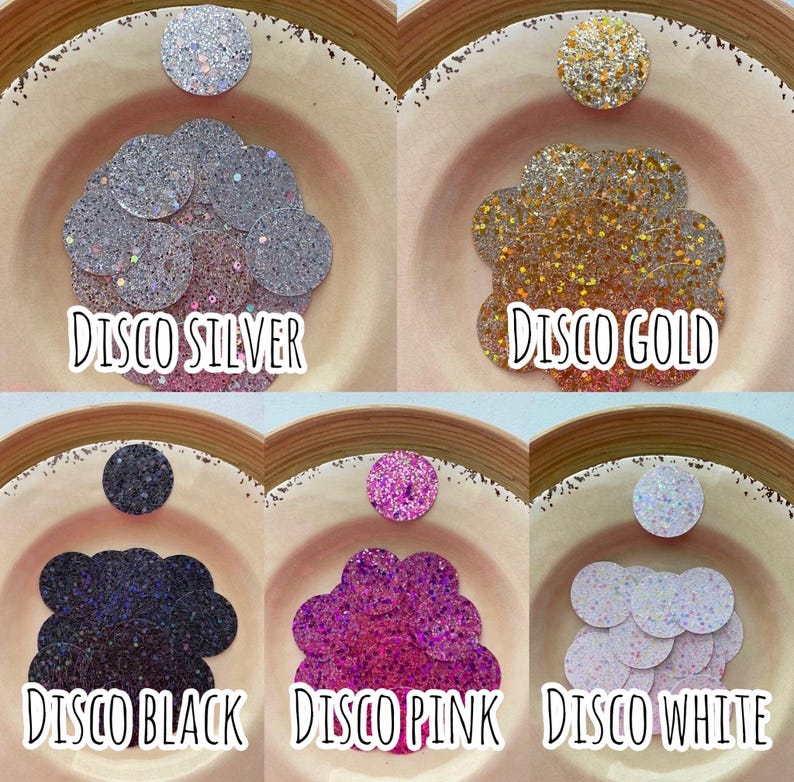 May include: Assortment of six small bowls filled with sparkly glitter in various colors, including silver, gold, black, pink, and white. Each bowl is labeled with the color and the word "Disco".