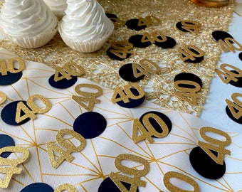 May include: Gold glitter 40th birthday confetti with black circles. The confetti is scattered on a white table with a gold and white pattern.