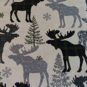 May include: A white fabric with a repeating pattern of moose silhouettes. The moose are in shades of grey and black with plaid patterns. There are also small green trees and snowflakes in the pattern.