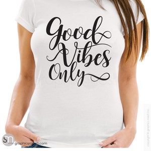 May include: White t-shirt with black text that reads "Good Vibes Only" in a cursive font.