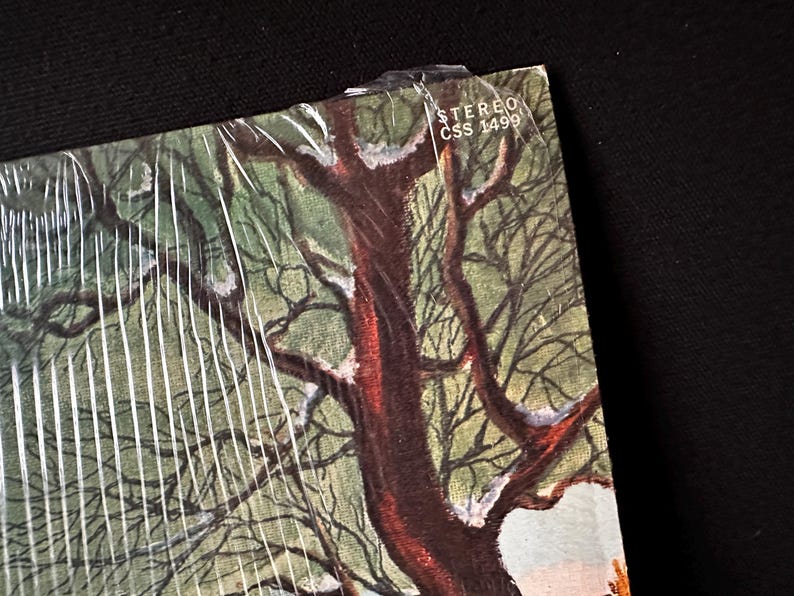 May include: A vintage vinyl record album cover featuring a snowy winter scene with a large tree in the center. The album cover has the text "STEREO CSS 1499" in the upper right corner.