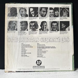 May include: A vintage vinyl record album cover with a white background and a black and white photo collage of singers. The album title is "Christmas Greetings" and the record label is "Columbia Special Products".