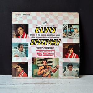 May include: Vintage Elvis Presley "Speedway" soundtrack album cover. The album features multiple images of Elvis, with the title in large yellow letters. The cover includes the RCA Victor logo and the text "Nancy Sinatra singing 'Your Groovy Self'".