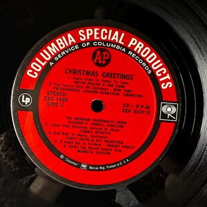 May include: Red and white vinyl record label with the text "Columbia Special Products" and "Christmas Greetings". The label lists the songs "Santa Claus Is Comin' To Town", "The Twelve Days Of Christmas", "Count Your Blessings", "God Rest Ye Merry, Gentlemen", "O Come All Ye Faithful", and "Hark! The Herald Angels Sing".
