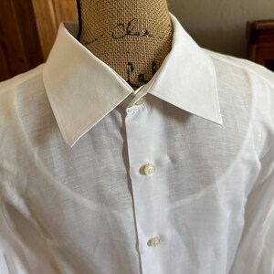 Peut inclure: Une chemise blanche à manches longues avec un col classique.