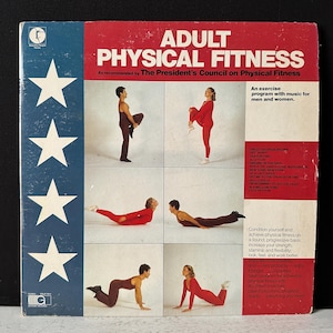 Könnte beinhalten: Ein Vintage-Schallplattencover mit einem blauen und weißen Sternenmuster auf der linken Seite. Das Cover ist mit "Adult Physical Fitness" betitelt und wird vom Präsidentenrat für körperliche Fitness empfohlen. Das Cover zeigt vier Schwarzweißfotos von Personen, die Übungen machen.