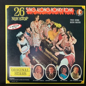 May include: A vintage vinyl record album cover featuring a group of singers in red, white and blue striped outfits. The album is titled "26 Sing Along Honky Tonk Non Stop" and features the text "Original Stars" and "Free Song Book Inside".