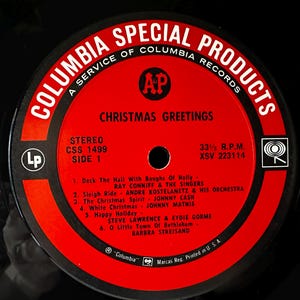 May include: Red and white vinyl record label with the text "Columbia Special Products" and "Christmas Greetings". The label lists six Christmas songs with the artists and a stereo record number.