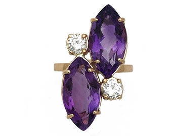 Könnte beinhalten: Ein goldener Ring mit zwei marquiseförmigen Amethyst-Edelsteinen und zwei runden Brillanten.