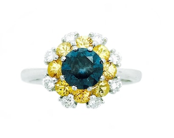 Könnte beinhalten: Ein silberner Ring mit einem blauen Saphir, umgeben von gelben und weißen Diamanten.