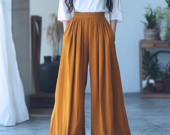 May include: Wide-leg, mustard yellow pants with a high waist and pleats. The pants are made of a lightweight fabric and have a relaxed fit.