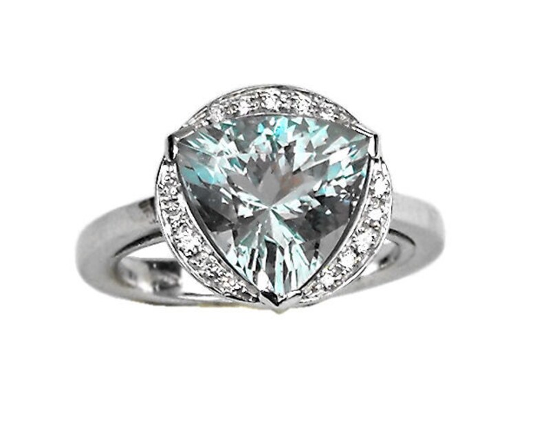 May include: A silver ring with a large triangular aquamarine gemstone surrounded by a halo of smaller diamonds.
