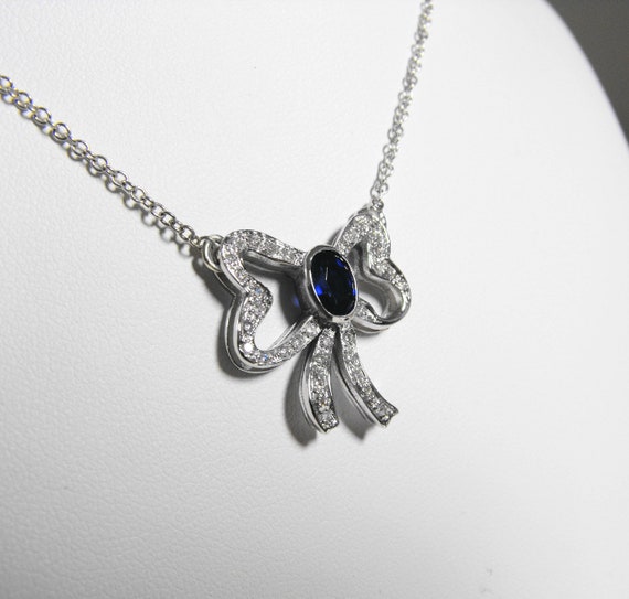 Collana con ciondolo in oro bianco a forma di fiocco con zaffiro blu da 0.98 Ct  con diamanti laboratorio 0.40 Ct