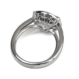 May include: A silver ring with a large, clear stone surrounded by smaller stones.