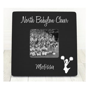 May include: Black wooden picture frame with a white silhouette of a cheerleader and the text "North Babylon Cheer" and "Melissa".