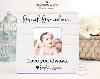 May include: White wooden picture frame with a whitewashed woodgrain finish. The frame has a small opening for a photo and the text "Great Grandma." and "Love you always." with a heart and the name "Sophia Lynn".