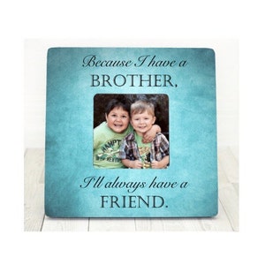 Puede incluir: Un marco de fotos azul turquesa con un paspartú blanco y una foto de dos niños pequeños. El marco tiene el texto "Because I have a BROTHER, I'll always have a FRIEND." impreso en él.