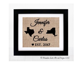 Puede incluir: Una impresión enmarcada en arpillera con el texto "Jennifer & Carlos EST. 2017" y siluetas de los estados de Texas y Nueva York.