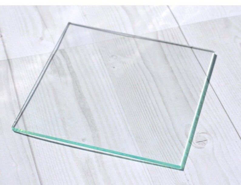 May include: A clear glass square with beveled edges.