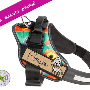 Peut inclure: Un harnais de chien noir avec un motif floral coloré et une étiquette de nom marron qui dit "Pongo". Le harnais a une bande réfléchissante blanche et une sangle noire réglable.