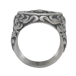K&ouml;nnte beinhalten: Ein silberner Ring mit einem komplizierten Design, das ein florales Motiv und ein zentrales Design aufweist. Der Ring ist aus Metall und hat eine polierte Oberfl&auml;che.