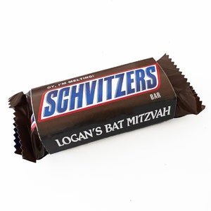 May include: A brown chocolate bar with the text "Schvitzers" in blue and white letters. The bar is wrapped in a brown foil wrapper with the text "Oy, I'm Melting!" and "Logan's Bat Mitzvah" printed on it.