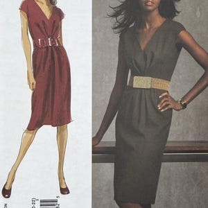 Puede incluir: Un sobre de patrón de costura para un vestido de Anne Klein Vogue American Designer. El diseño presenta un vestido hasta la rodilla con escote en V, mangas cortas y un cinturón ancho en la cintura. La portada muestra una ilustración y una foto.
