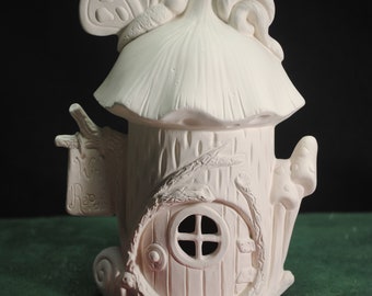 May include: White ceramic fairy house with a mushroom roof, a butterfly on top, and a small door with a window. The house is decorated with vines and leaves.