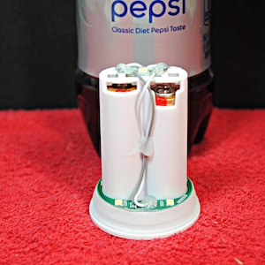 May include: A white plastic battery holder with two AA batteries inside. The holder has a green circuit board with several LED lights. The text "Y00010" is printed on the circuit board.
