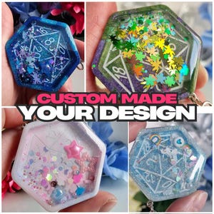 Op de afbeelding: Vier op maat gemaakte hars-dobbelstenen bedels met verschillende ontwerpen en kleuren. De dobbelstenen zijn zeshoekig en hebben een glinsterende afwerking. De tekst "CUSTOM MADE YOUR DESIGN" is zichtbaar in het midden van de afbeelding.