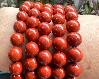 May include: A bracelet made of multiple strands of red gemstone beads. The beads are round and have a smooth, polished finish.