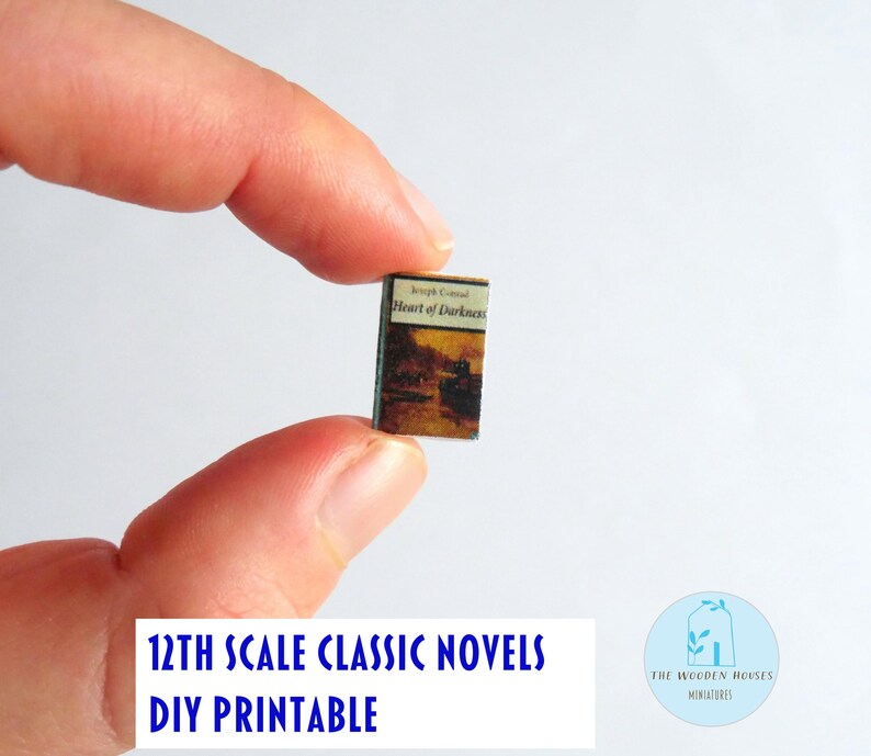 May include: A tiny book, titled "Heart of Darkness" by Joseph Conrad, held up. The cover is brown and beige with a landscape scene. The text at the bottom says "12th Scale Classic Novels DIY Printable".