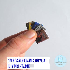 May include: A hand holding a small stack of miniature classic novels. The book covers are visible, with titles including "Tom Sawyer" and "MAM SIROKER Descule". The text "12TH SCALE CLASSIC NOVELS DIY PRINTABLE" is at the bottom.