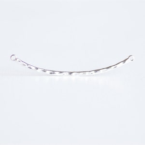 May include: A silver hammered metal bar with two small loops at each end. The bar is curved slightly.