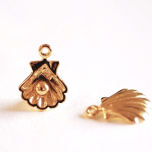 May include: Two gold-colored metal shell-shaped charms with a loop at the top for attaching to jewelry or other crafts.