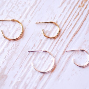 May include: Three pairs of hoop earrings in different sizes. The earrings are made of gold and silver metal.