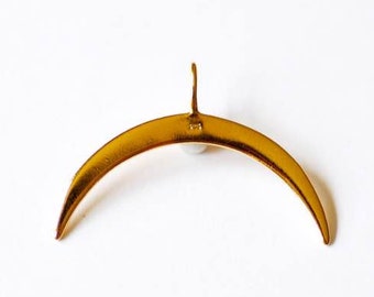 May include: A gold-colored, crescent-shaped earring with a small hook at the top. The earring has a smooth, polished surface and is set against a white background. The design is minimalist and elegant.